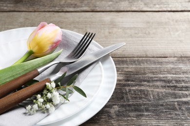 Photo of Stylish table setting with cutlery and flowers on wooden background. Space for text