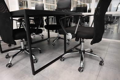 Photo of Comfortable office chairs and tables in meeting room