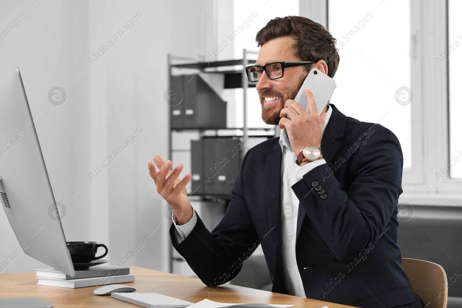 Photo of Happy bearded man talking on smartphone in office