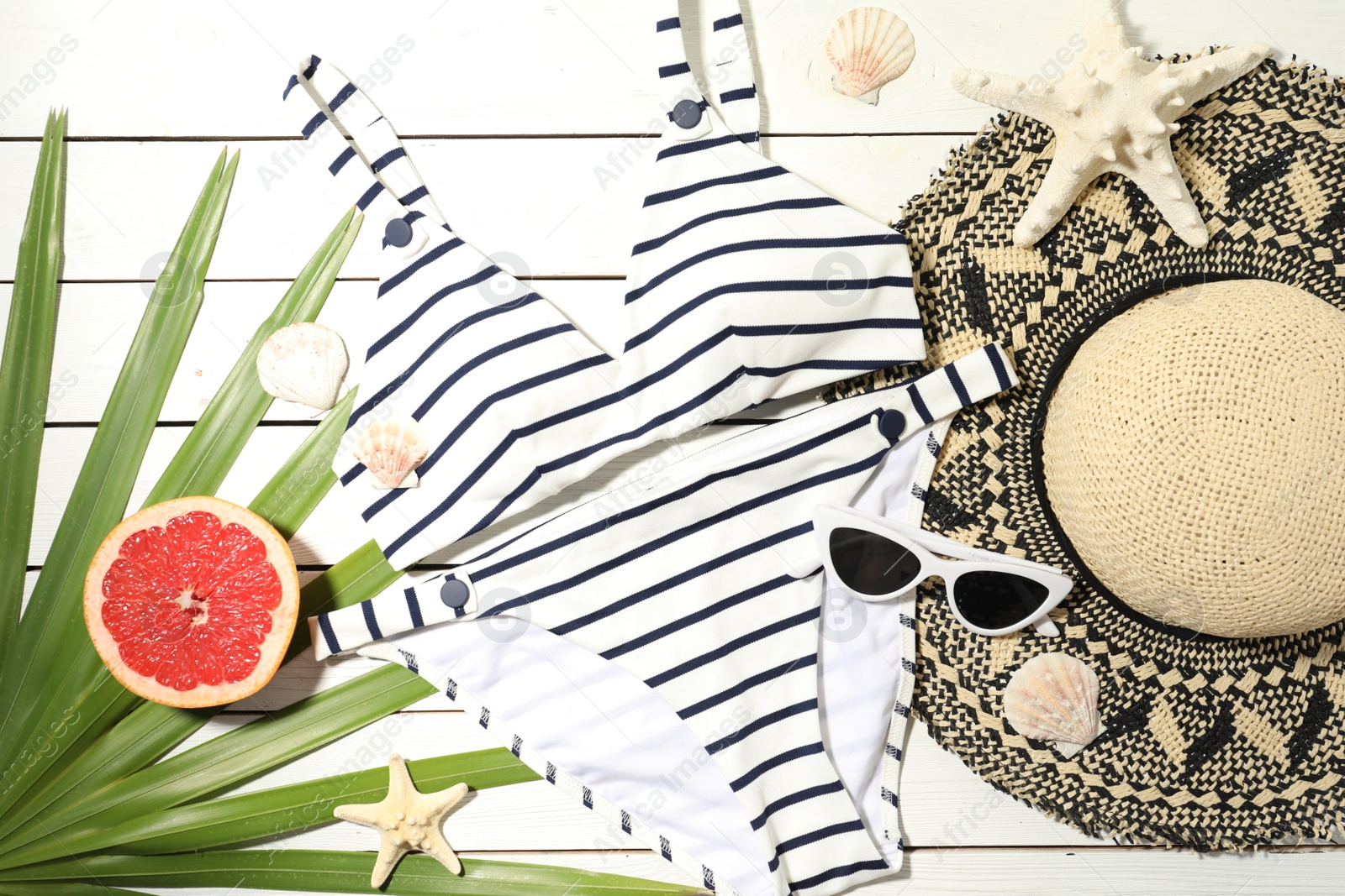 Photo of Flat lay composition with grapefruit and beach objects on white wooden background