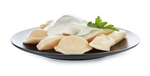 Delicious cooked dumplings with sour cream on white background