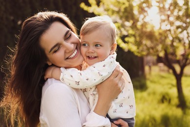 Image of Happy mother with her cute baby in park on sunny day