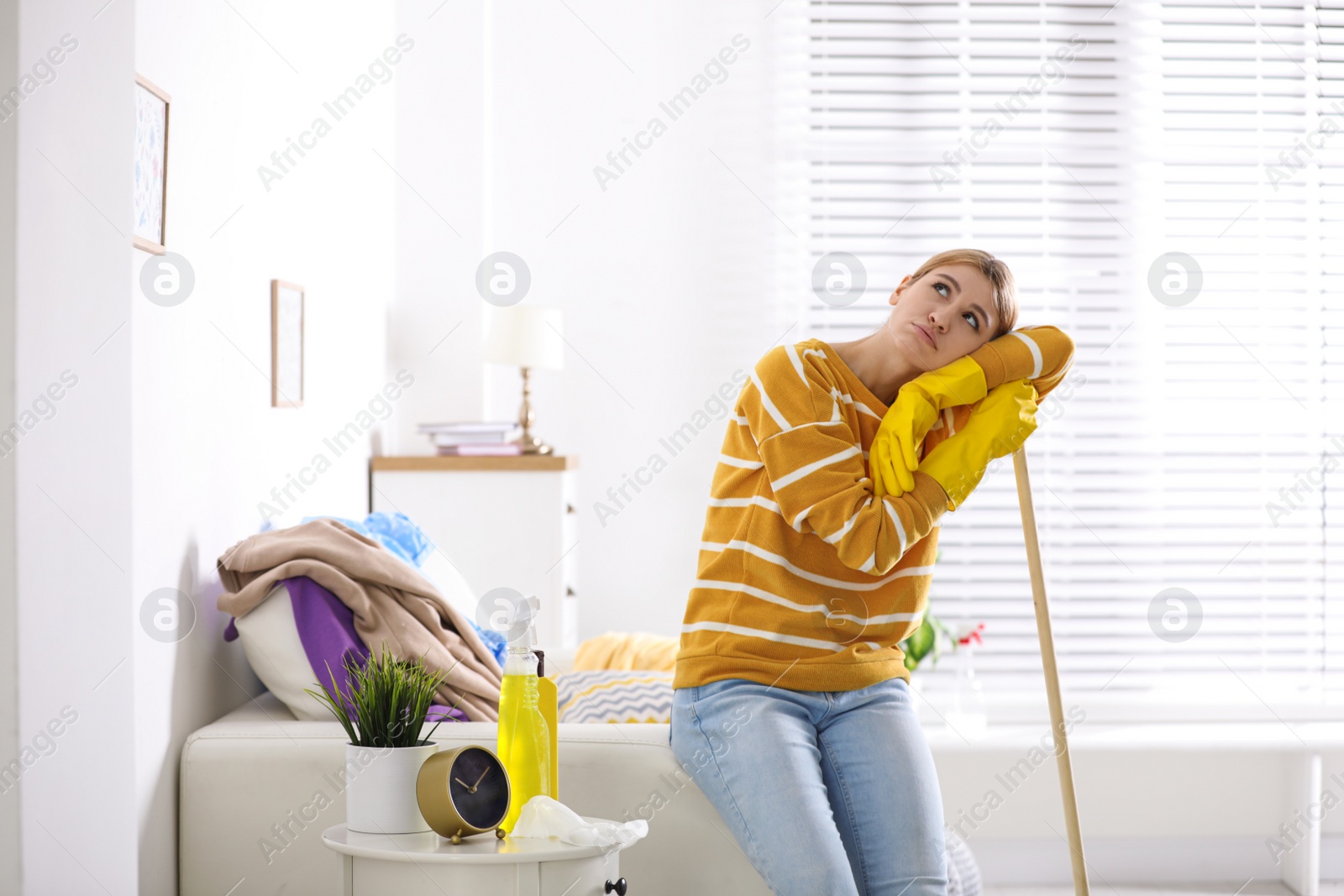 Photo of Lazy young woman with mop at home. Cleaning and housework