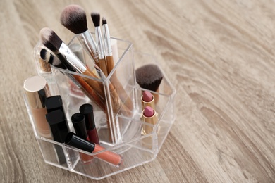 Photo of Organizer with cosmetic products for makeup on table