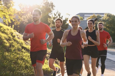 Photo of Group of people running outdoors on sunny day