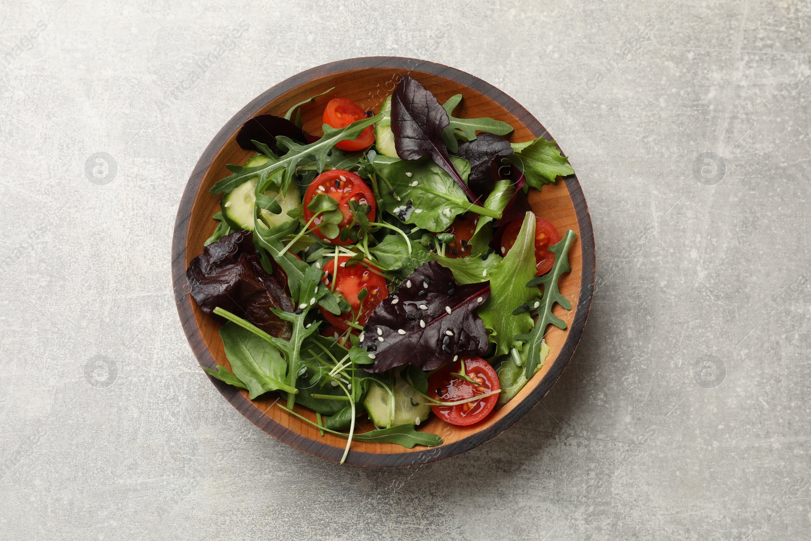 Photo of Tasty fresh vegetarian salad on grey table, top view