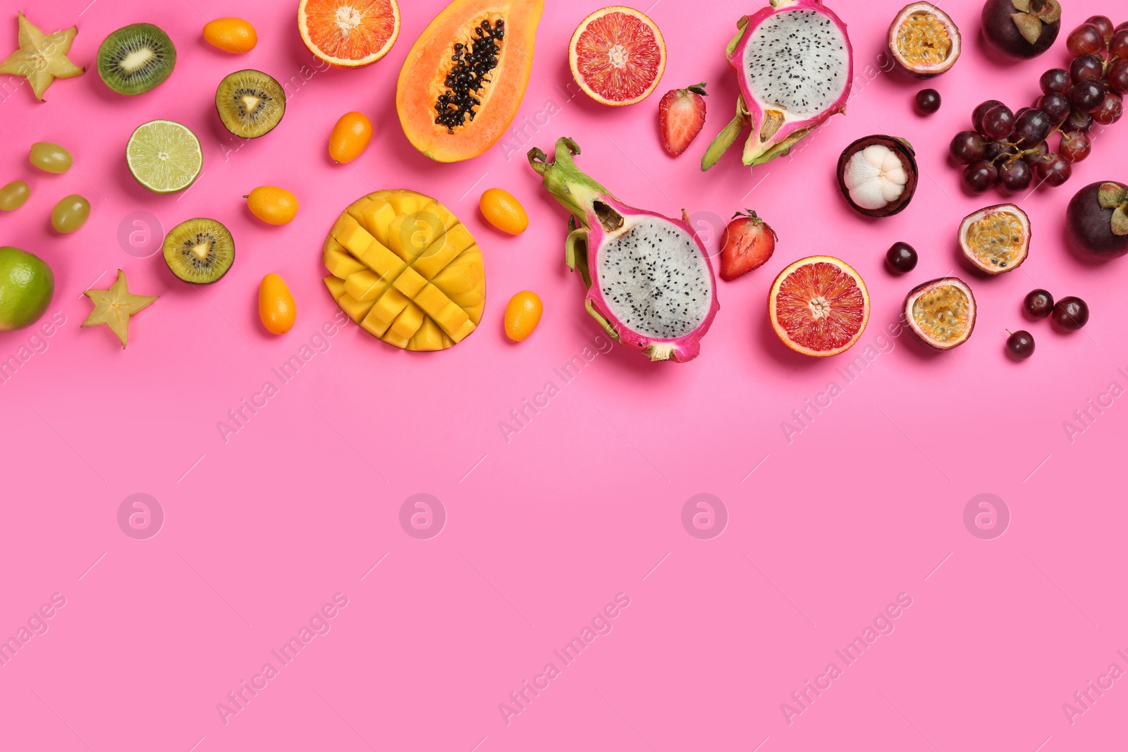 Photo of Many different delicious exotic fruits on pink background, flat lay. Space for text