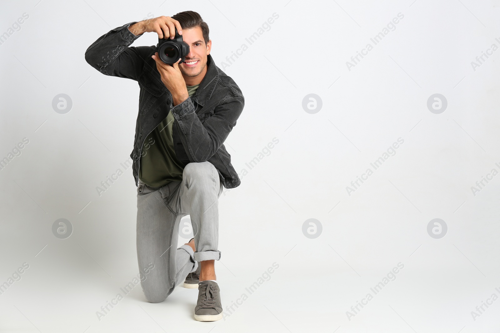 Photo of Professional photographer working on white background in studio