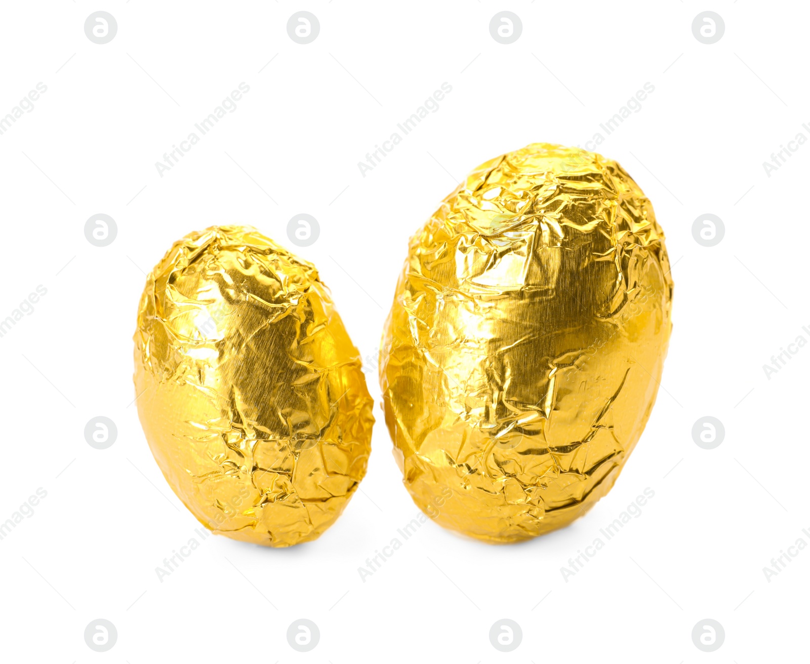 Photo of Chocolate eggs wrapped in bright golden foil on white background