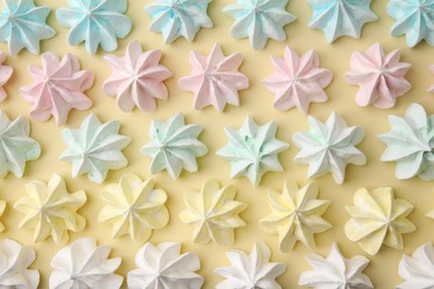 Delicious meringue cookies on beige background, flat lay