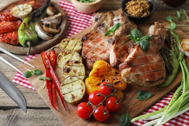 Photo of Delicious grilled meat and vegetables served on wooden table, closeup