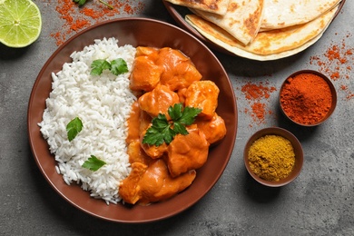 Photo of Butter chicken with rice served on grey table, flat lay