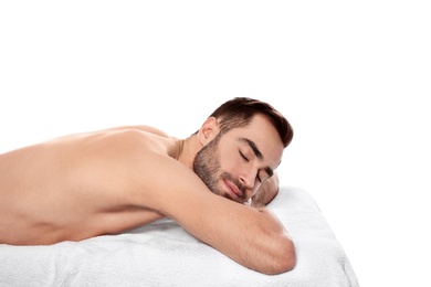 Photo of Handsome man relaxing on massage table against white background. Spa service