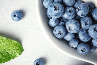 Photo of Flat lay composition with juicy and fresh blueberries on color table