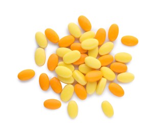 Photo of Tasty yellow and orange dragee candies on white background, top view