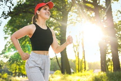 Young woman running outdoors in morning. Space for text