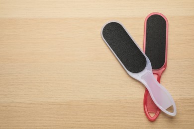 Colorful foot files on wooden table, flat lay with space for text. Pedicure tools