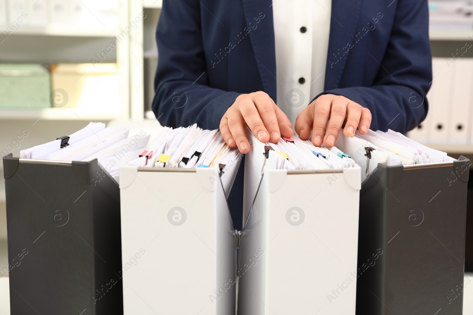 Photo of Woman taking documents from folder in archive, closeup