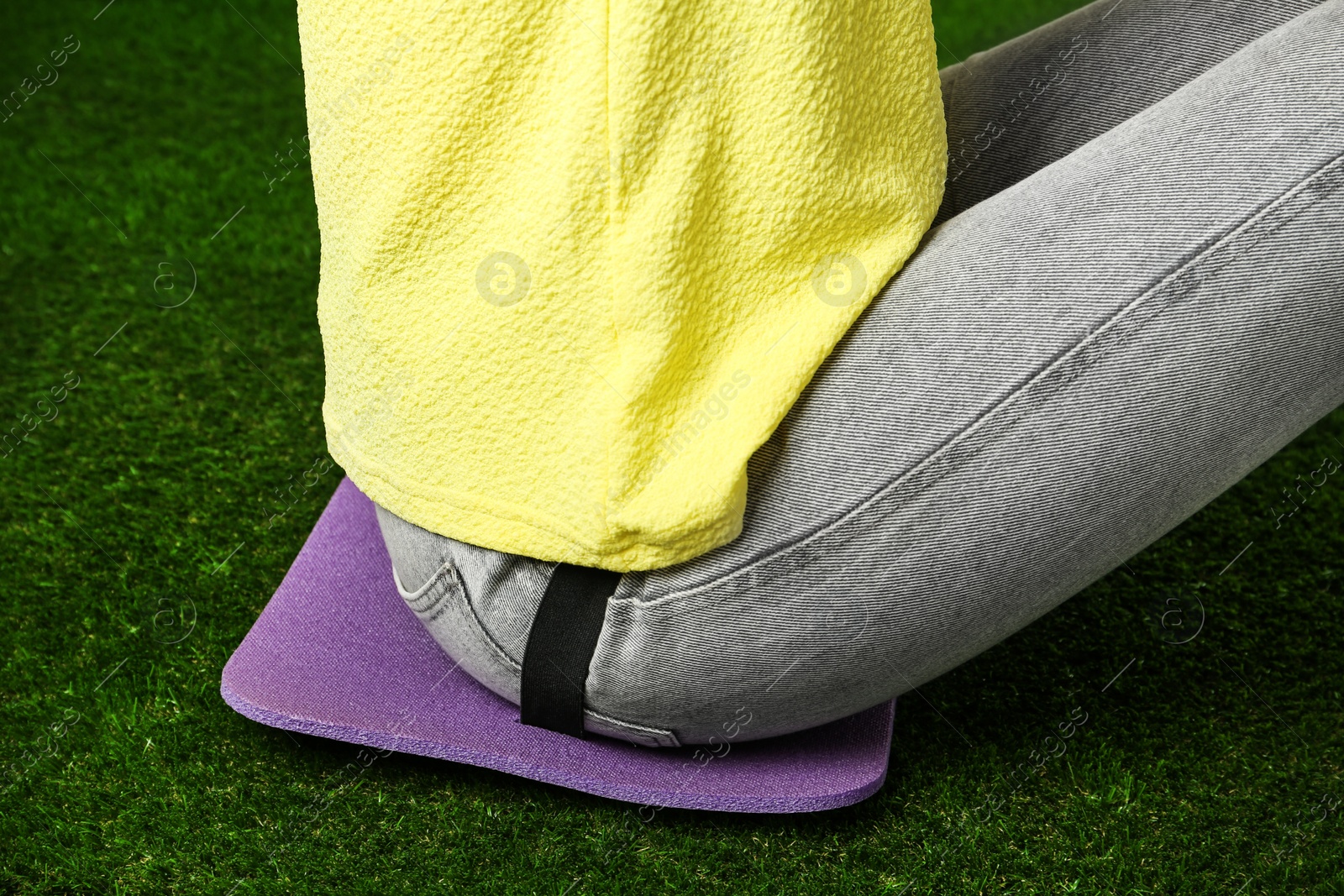 Photo of Woman sitting on foam tourist mat outdoors, closeup