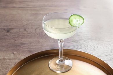 Glass of tasty cucumber martini on wooden table