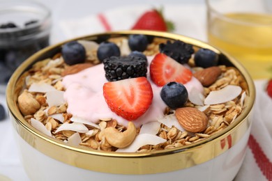 Photo of Tasty granola, yogurt and fresh berries in bowl, closeup. Healthy breakfast