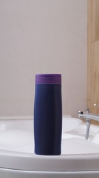 Photo of Purple bottle of bubble bath on tub indoors