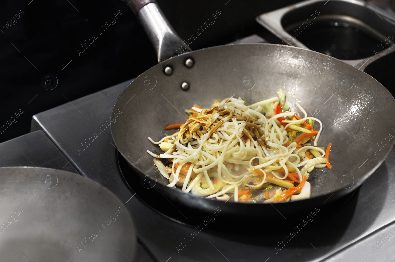 Photo of Delicious noodles with shrimps and fresh vegetables in frying pan