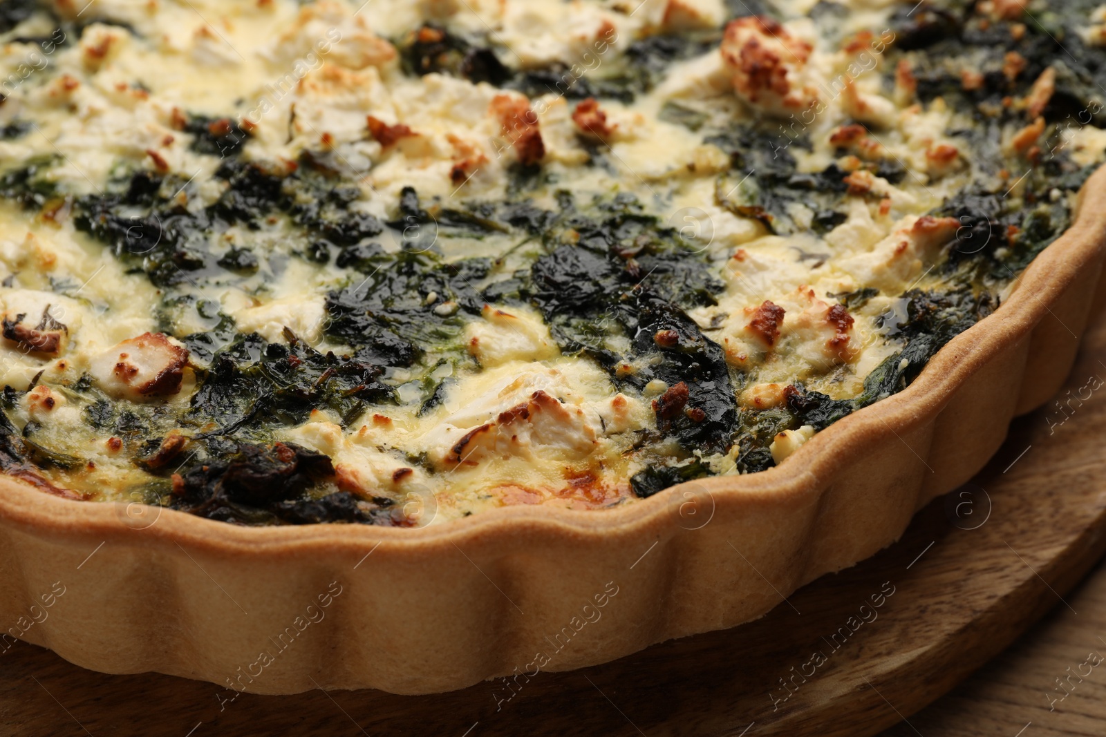 Photo of Delicious homemade spinach quiche on table, closeup