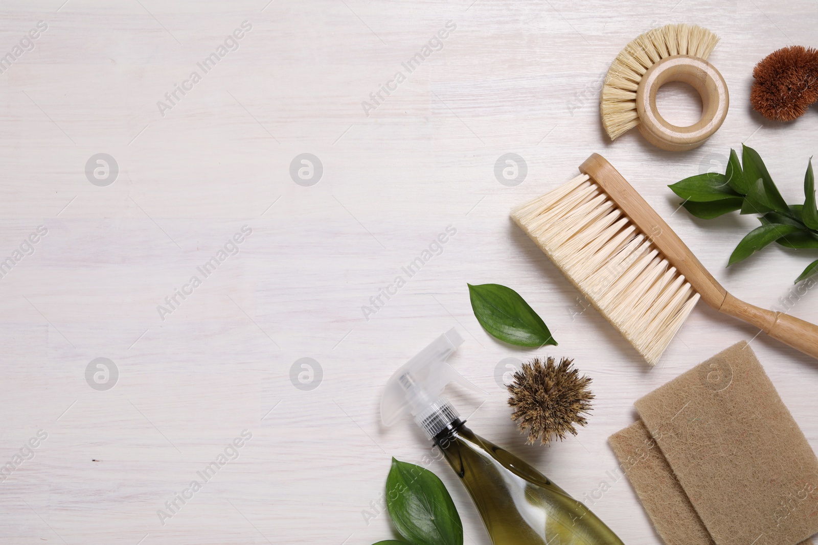 Photo of Flat lay composition with different cleaning supplies on light wooden background, space for text