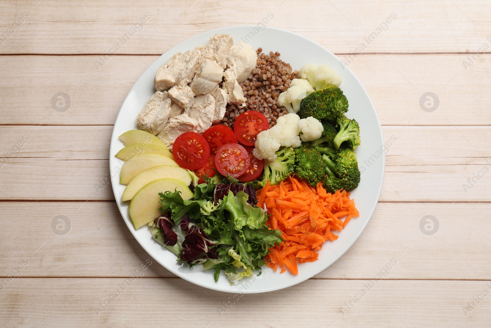 Photo of Balanced diet and healthy foods. Plate with different delicious products on light wooden table, top view