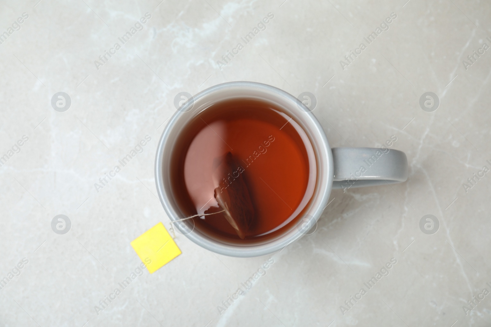 Photo of Cup of delicious hot tea on grey background, top view