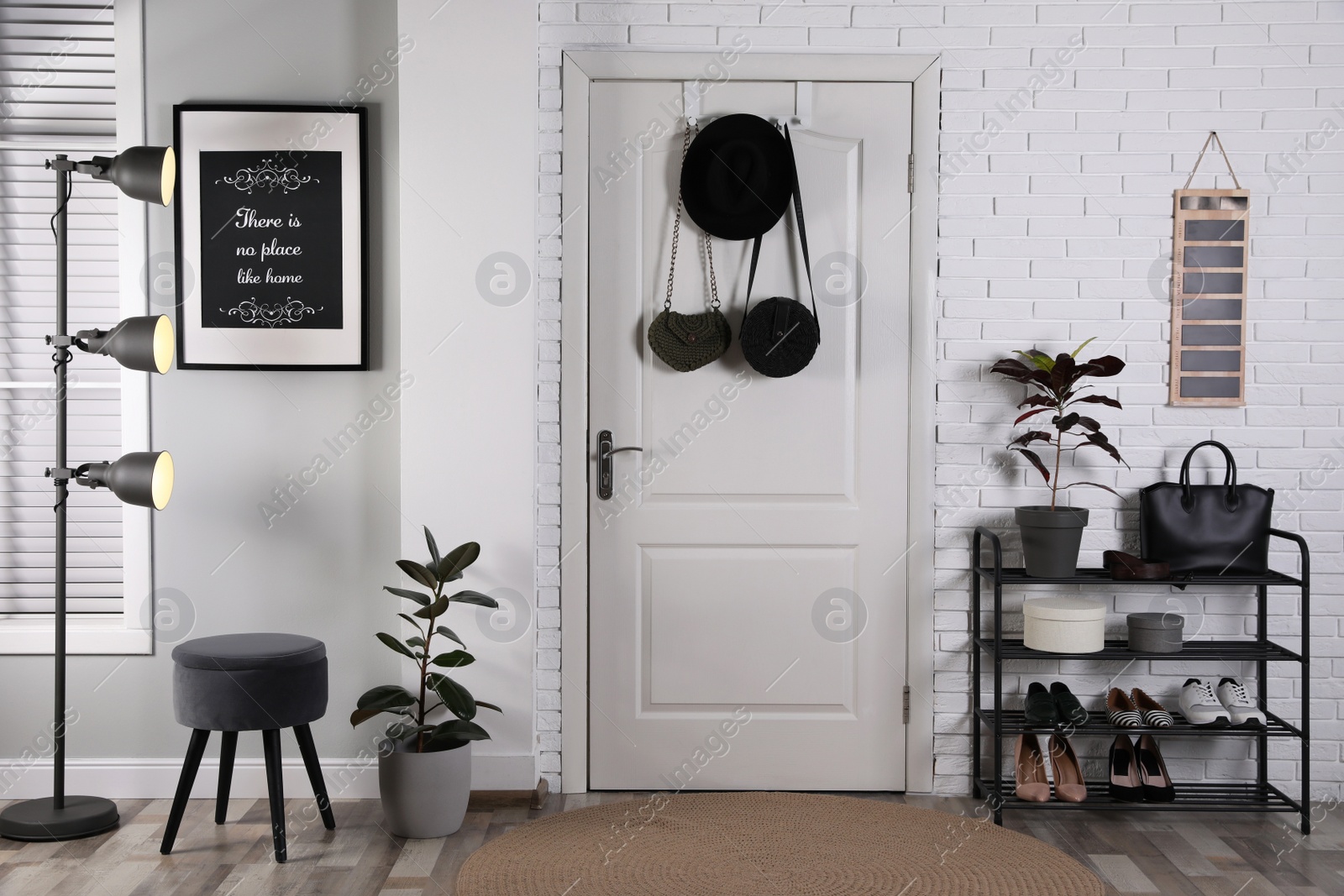 Photo of Hallway interior with stylish furniture, shoes and plants