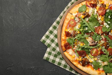 Photo of Delicious vegetarian pizza with cheese, mushrooms, vegetables and greens on black table, top view. Space for text