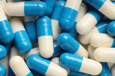 Many antibiotic pills as background, top view