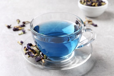 Photo of Glass cup of organic blue Anchan on light table. Herbal tea