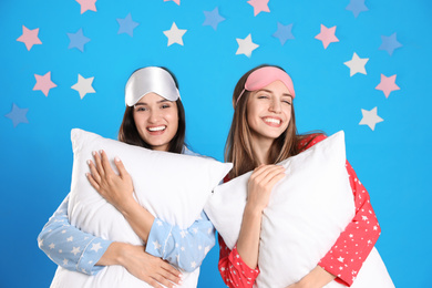 Photo of Beautiful women with pillows on light blue background. Bedtime