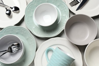 Photo of Beautiful ceramic dishware, cup and cutlery on light grey table, flat lay