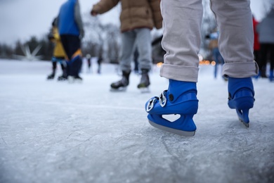 Person skating at outdoor ice rink, closeup