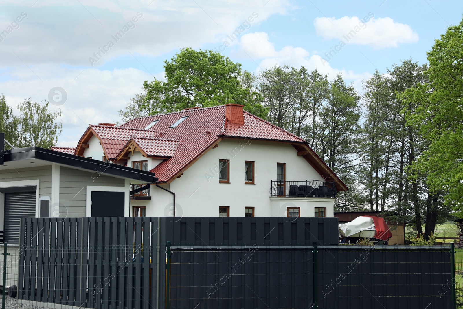 Photo of Modern building with red roof outdoors on sunny day