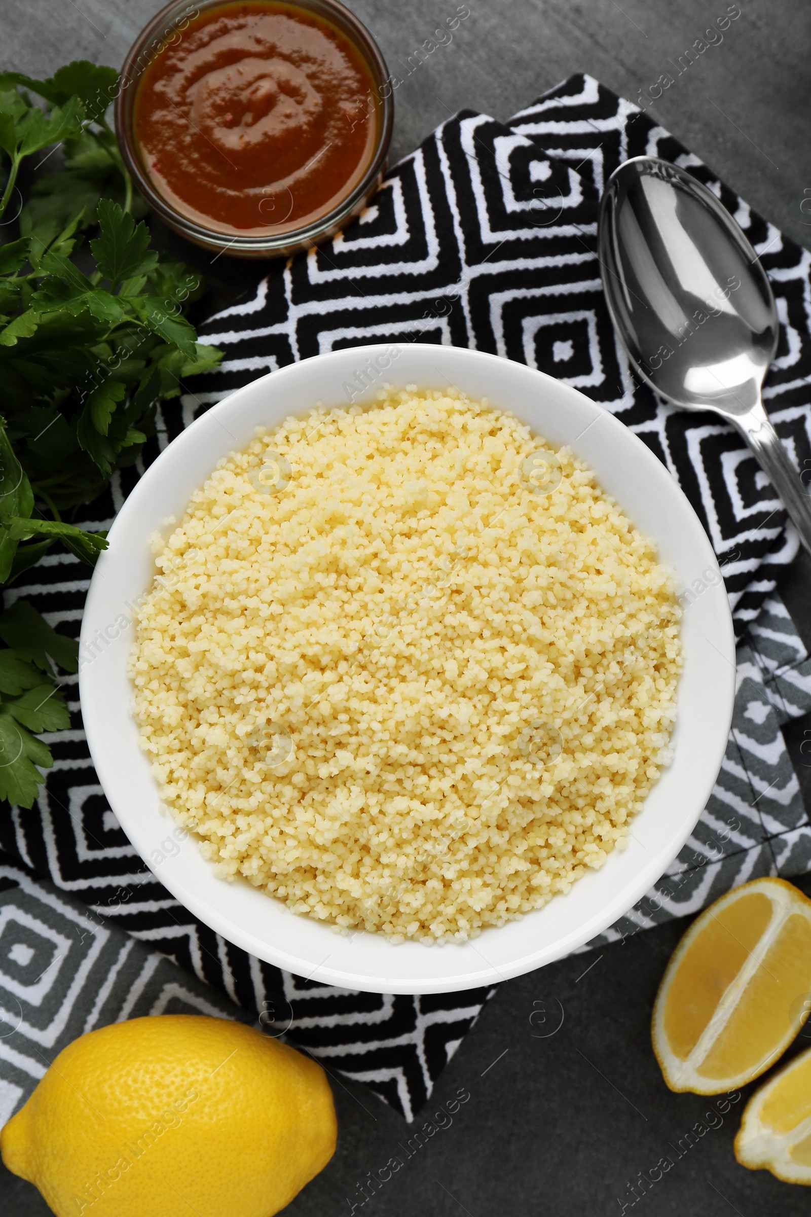 Photo of Tasty couscous and ingredients on grey table, flat lay