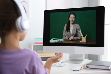 Distance learning, studying at home. Girl having online school lesson with teacher during quarantine and lockdown due to Covid-19 pandemic