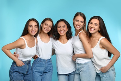 Photo of Happy women on light blue background. Girl power concept