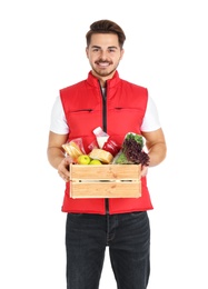 Photo of Young man holding wooden crate with products on white background. Food delivery service