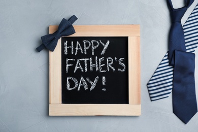 Photo of Flat lay composition with blackboard and ties on gray background. Happy Father's Day