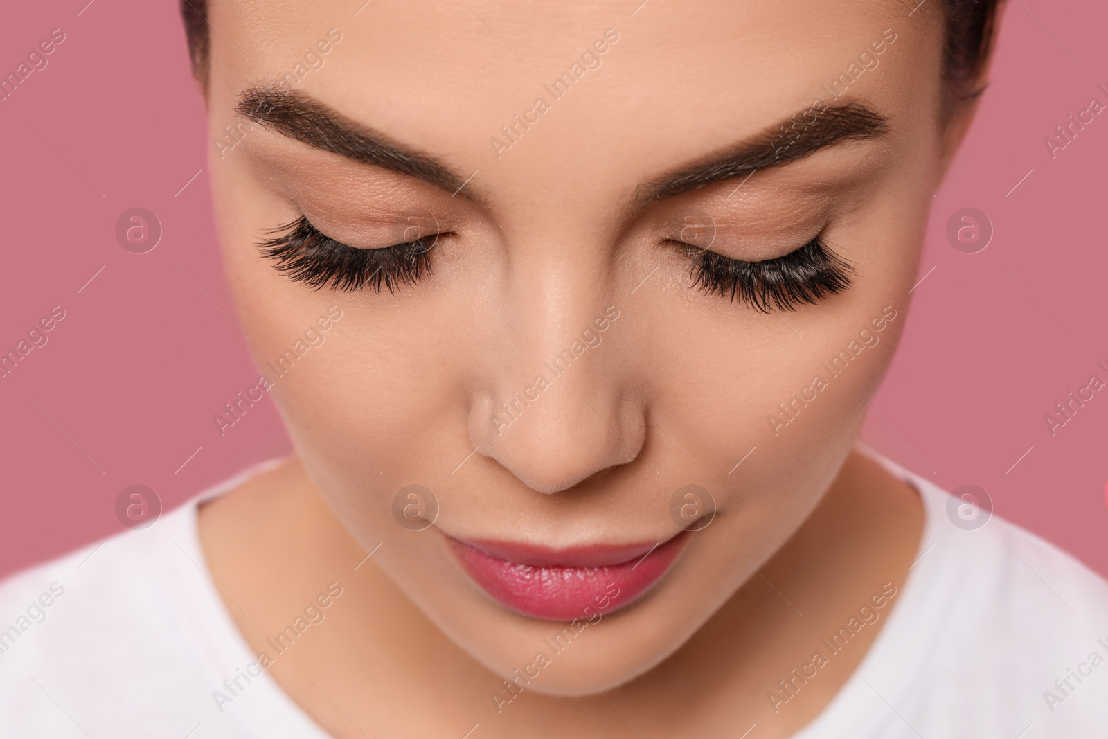 Photo of Beautiful young woman with long eyelashes on pink background, closeup