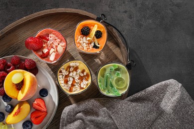 Photo of Many different delicious smoothies and ingredients on grey table, flat lay. Space for text