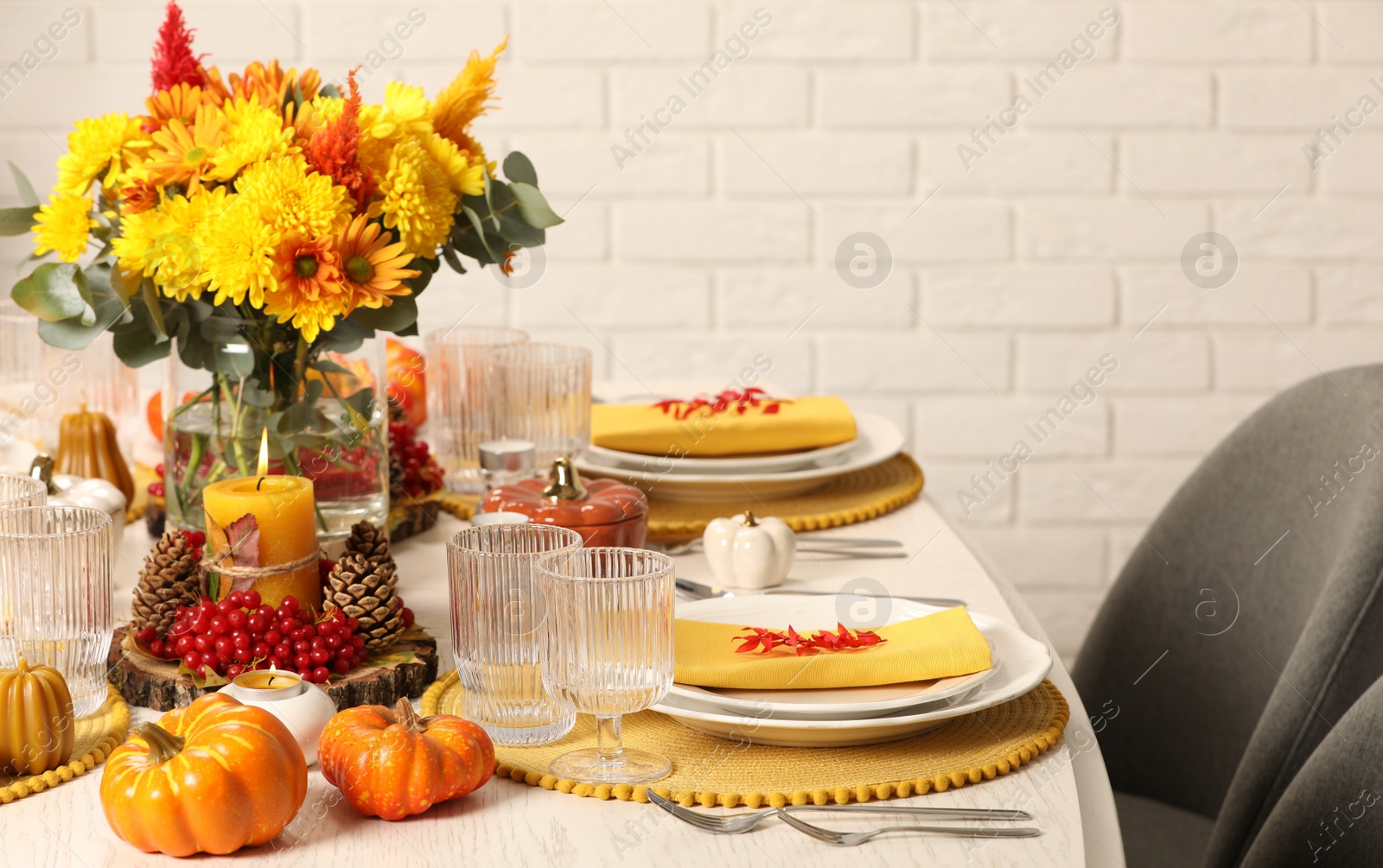 Photo of Autumn table setting with floral decor and pumpkins indoors