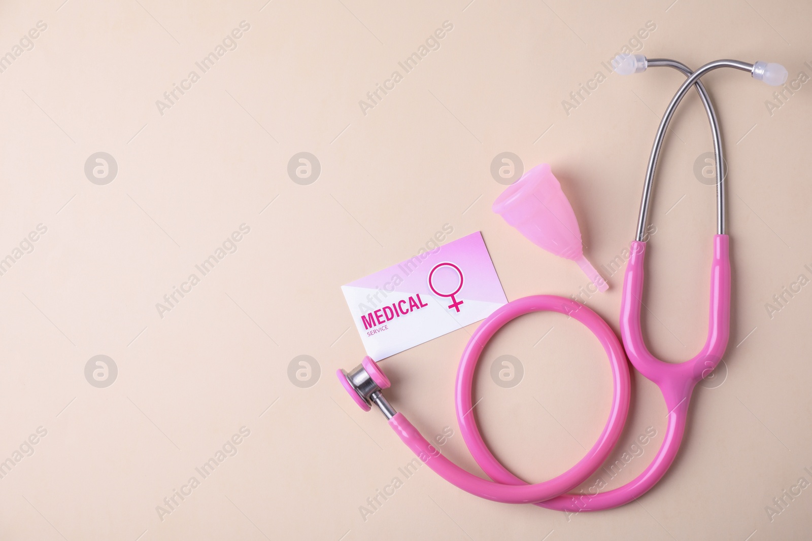 Photo of Menstrual cup, stethoscope and business card on color background, flat lay with space for text. Gynecological care