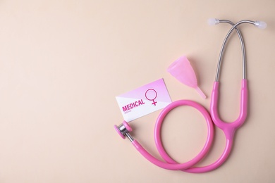 Photo of Menstrual cup, stethoscope and business card on color background, flat lay with space for text. Gynecological care