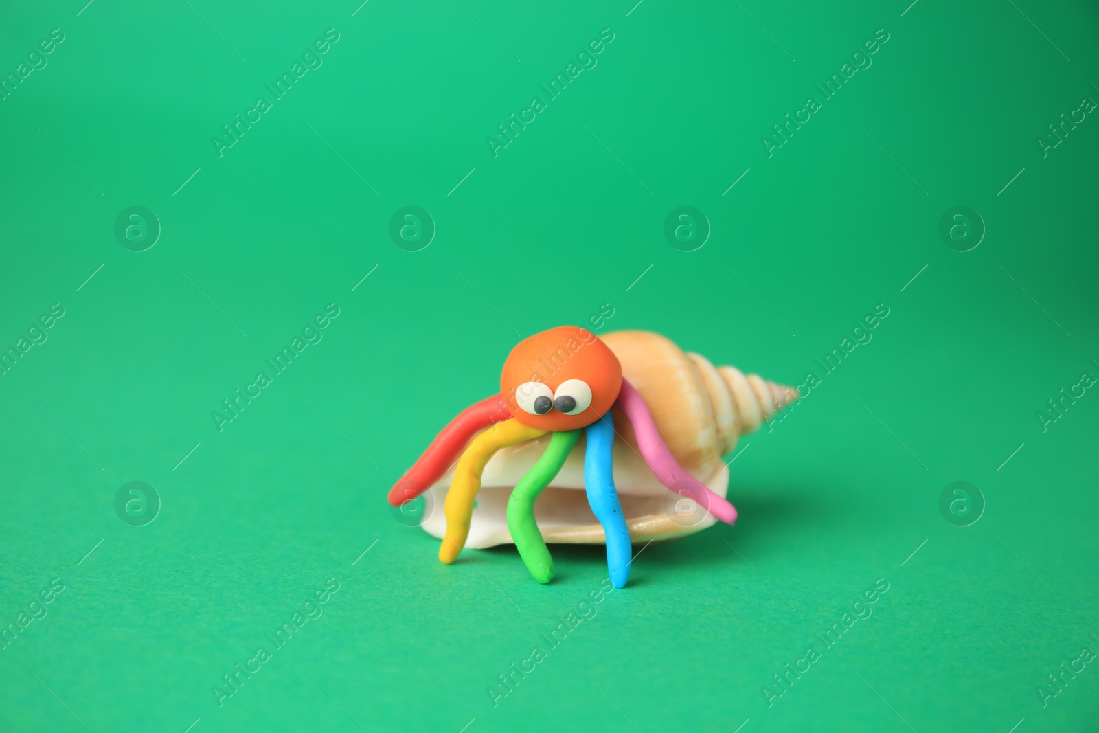 Photo of Crab made from plasticine on green background. Children's handmade ideas